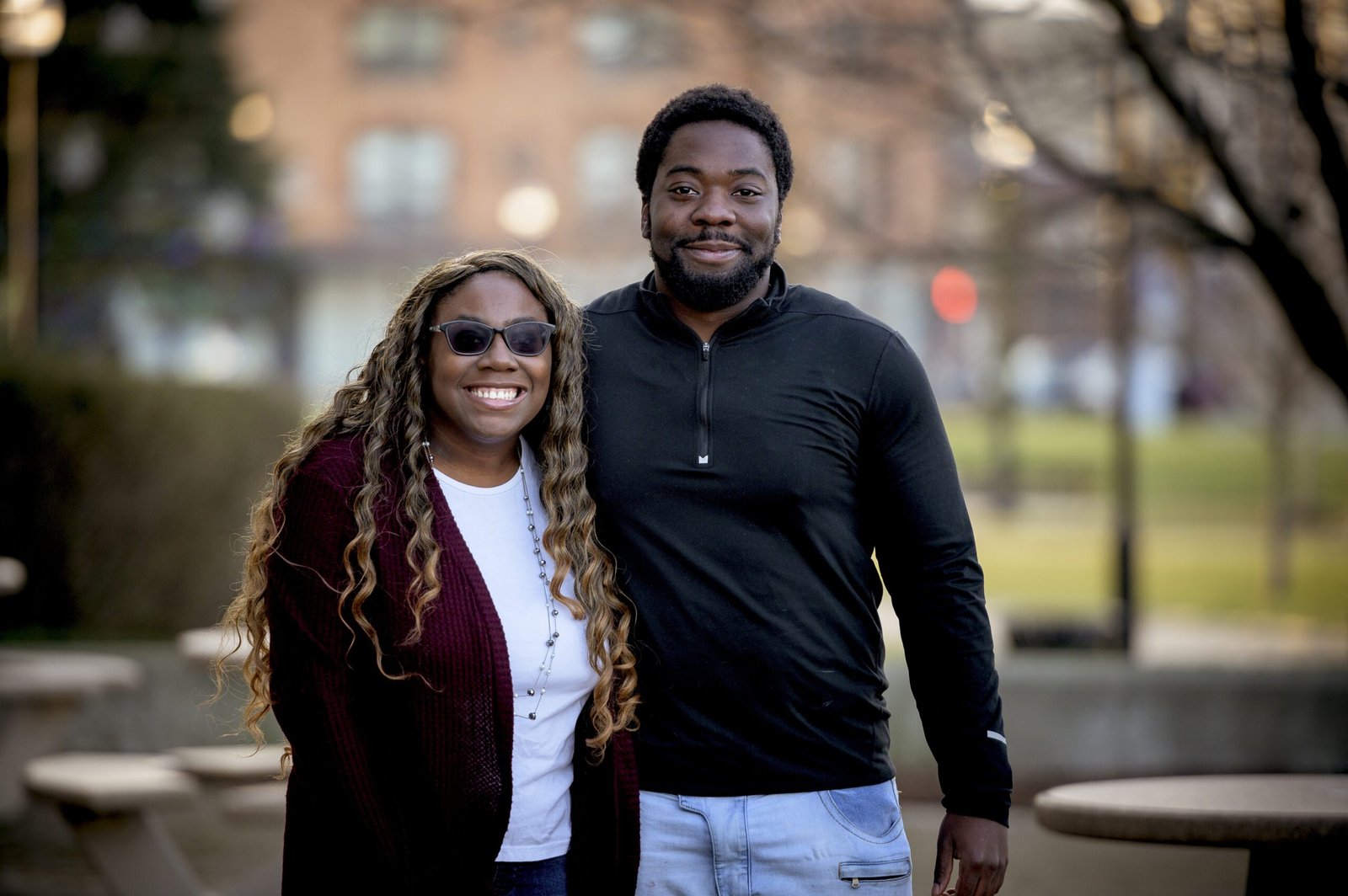 An African-American couple in a park under sunlight with a blurry background